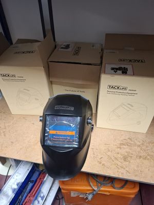 many boxes on a shelf with a welding helmet on it