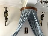 a bed with a canopy over it in a room with a chandelier