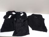 trois paires de chemises et de pantalons noirs posées sur une table blanche