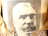 a picture of a man sitting in a chair with a book on it