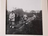 a black and white photo of a group of men working on a field