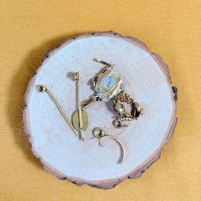 une petite assiette posée sur une table, sur laquelle se trouvent quelques bijoux