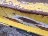 a close up of a piece of yellow paint on the side of a truck