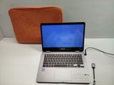 un ordinateur portable posé sur une table, avec un stylo à côté