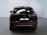 the rear end of a black car in a white room