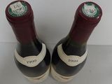 pair of two bottles of wine sitting on top of a white table