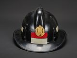 a black fireman ' s helmet with a gold emblem on it