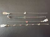 cinq bracelets différents ornés de breloques et de pendentifs