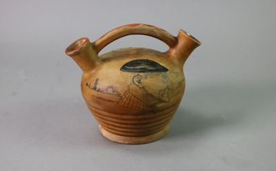 a brown vase with a bird on it on a table