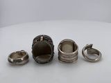 three silver rings and two silver rings with blue stones on them