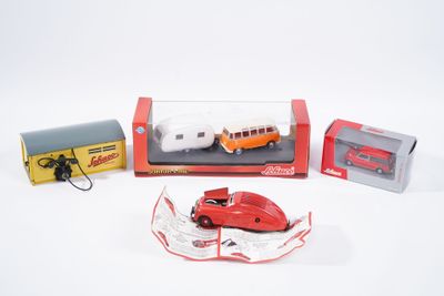 une petite voiture rouge et d'autres véhicules miniatures dans une boîte