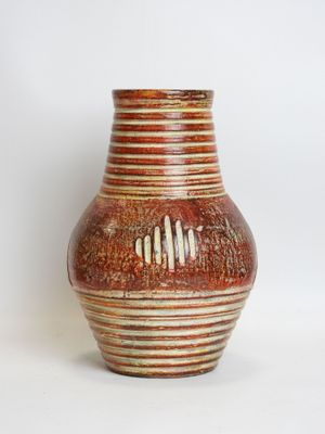 a brown vase that is sitting on a white surface
