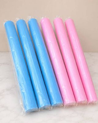 four pink and blue candles sitting on top of a marble counter