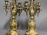 pair of antique brass candelabs on stand on grey background