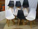 plusieurs chaises blanches et noires disposées devant un fond blanc