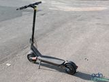 a scooter that is sitting on the ground in the parking lot