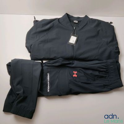 un gros plan d'une veste et d'un pantalon noirs posés sur une surface blanche