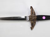 a knife with a pink dot on it laying on a white surface