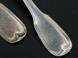 two spoons and a fork on a black table