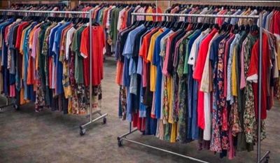 beaucoup de vêtements suspendus à une étagère dans une pièce