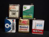 quatre bidons d'huile moteur sont empilés les uns sur les autres