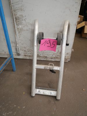 une échelle sur laquelle est accrochée une pancarte, devant une porte