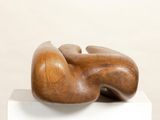 a wooden sculpture on top of a white pedestal