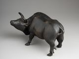 bronze figurine of a bull on a white background