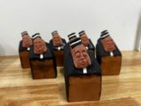cinq figurines représentant des hommes en costume et chapeau, posées sur une table en bois