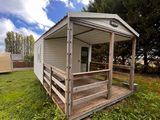 une photo d'une petite cabane dans l'herbe