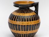 un vase noir et marron muni d'une anse, sur fond blanc