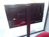a tv that is on a stand in front of a window