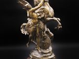 une statue en bronze représentant une femme à cheval tenant un oiseau
