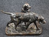 bronze statue of a dog and a cat on a rock
