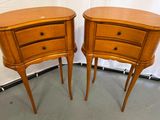pair of wooden nightstand tables with drawers on each side of them