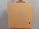 an easel with a blank canvas on top of it against a gray wall