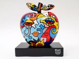a colorful apple sculpture on a black stand on a white background