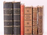 plusieurs vieux livres sont alignés sur une surface blanche