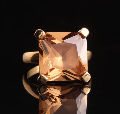 un gros plan d'une bague sertie d'une topaze orange
