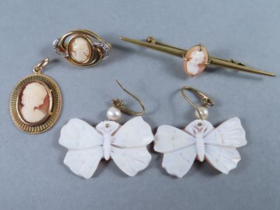 trois paires de boucles d'oreilles et une broche posées sur une table
