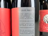 three bottles of red wine are lined up on a table