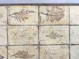 a tile with a pattern of leaves and leaves on it