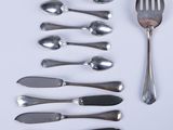 many spoons and forks laid out on a white surface