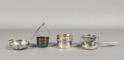 quatre tasses et cuillères en argent sont alignées sur une table