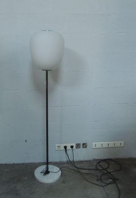 une lampe posée sur le sol à côté d'un mur