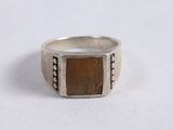 a close up of a silver ring with a tiger ' s eye stone in it