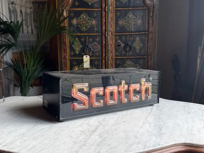a wooden sign that says scotch on it sitting on a table