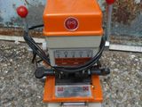 an orange and white machine sitting on top of a cement floor