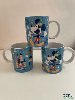 three mickey mouse mugs sitting on top of a white table