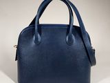 a blue leather handbag on a white background